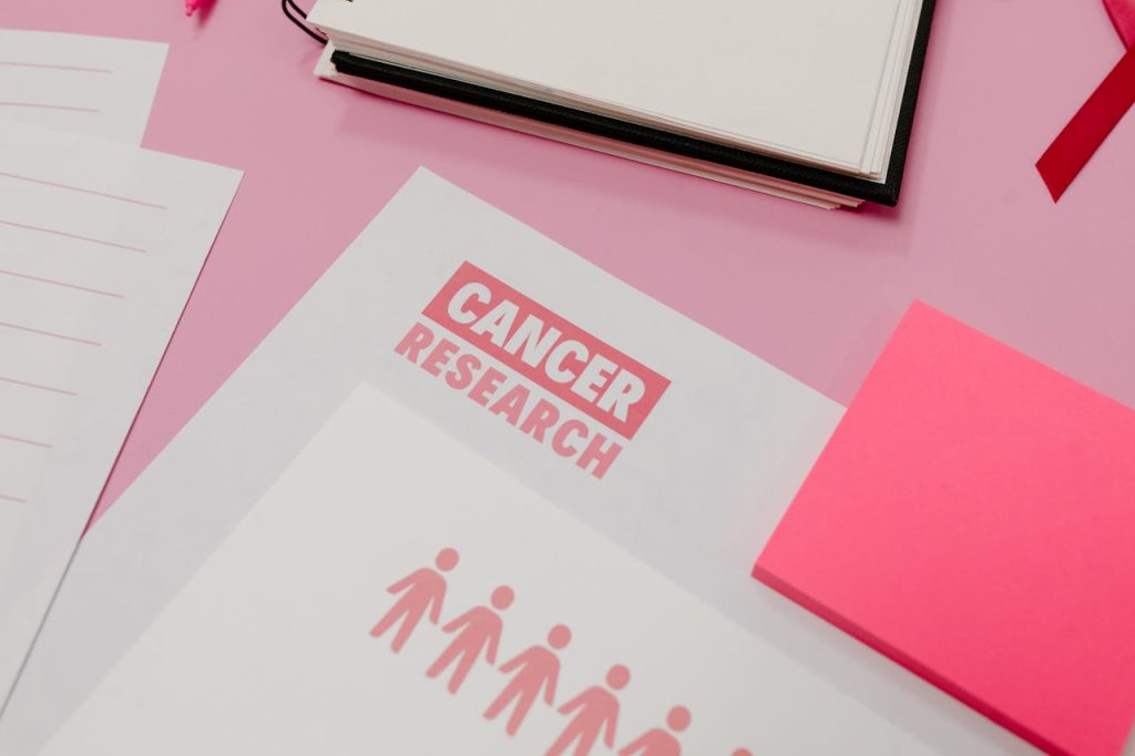 Mastering the First Impression: Your intriguing post title goes here Assorted cancer research materials laid on a pink desk. Professional workspace.